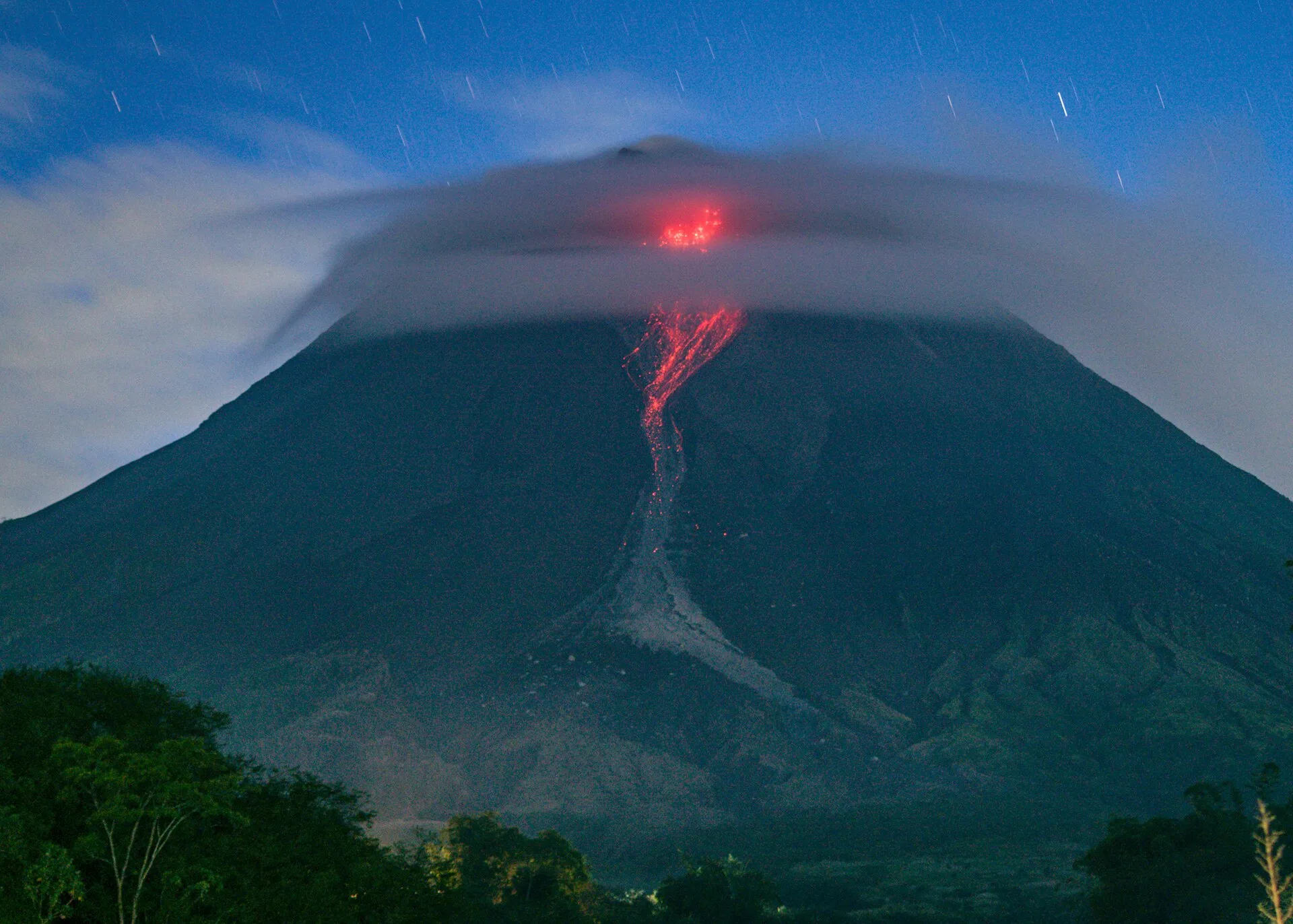 Guguran lava Gunung Merapi tampak membara meluncur di lereng gunung pada malam hari