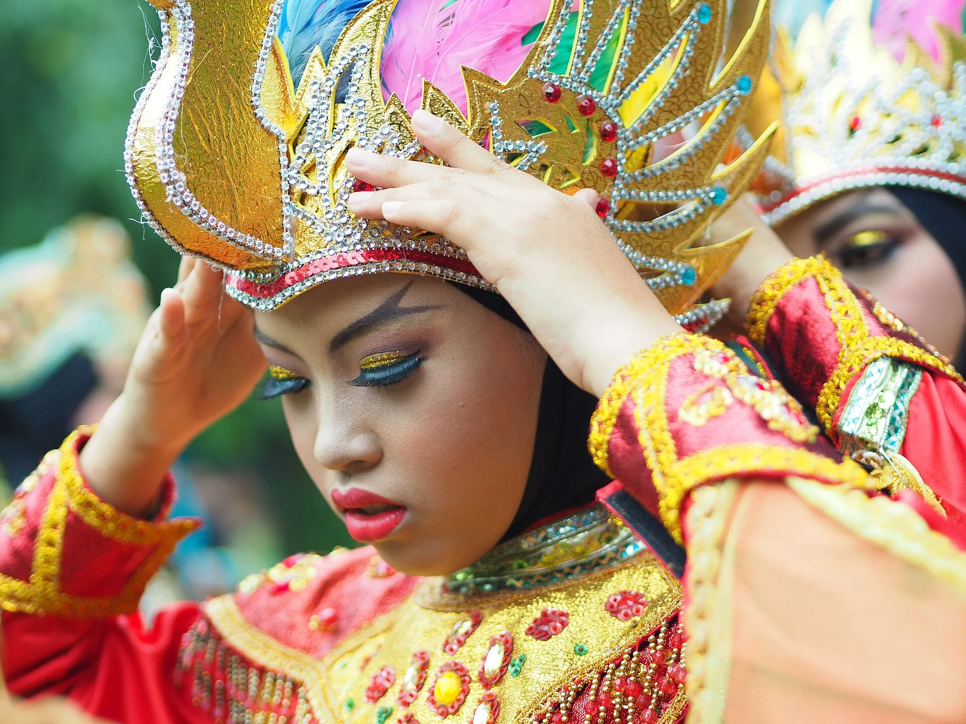Penari tradisional Indonesia mengenakan kostum dan mahkota keemasan